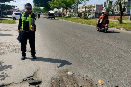 Polantas menunjukkan lokasi kecelakaan maut di Jalan Soekarno Hatta Pekanbaru.(foto: tribunpekanbaru.com)