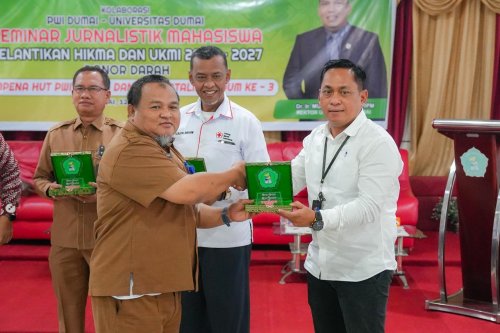 Wakil Rektor 2, Edi Susanto SE MMAk menyerahkan plakat kepada Ketua PWI Dumai, Bambang Prayetno SH.(foto: bambang/halloriau.com)